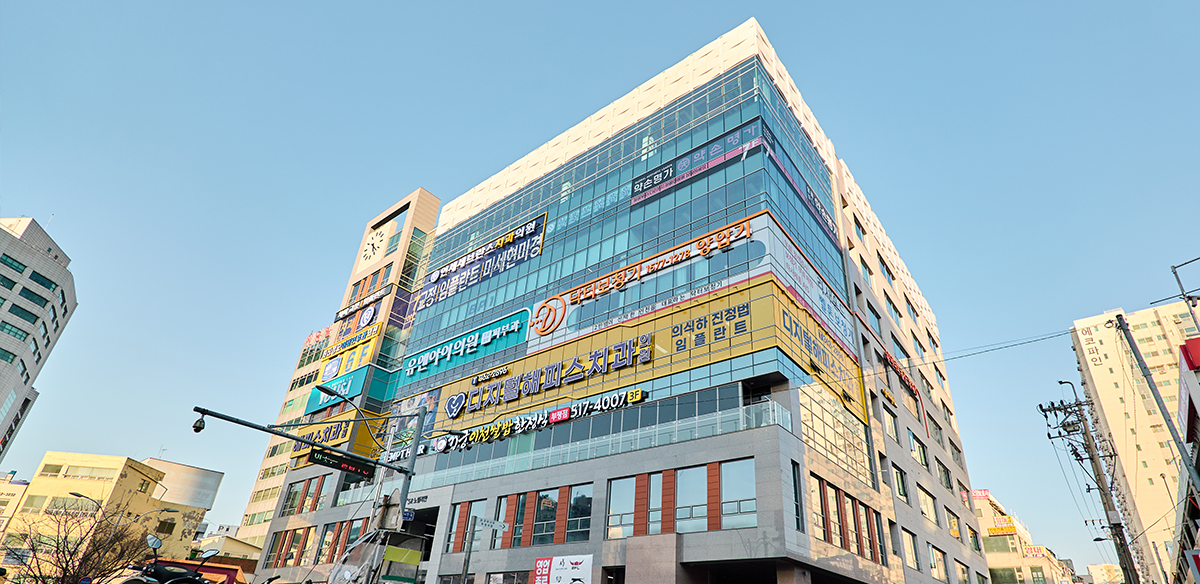 Exterior of the multi-story building housing Digital Happeace Dental Clinic, with clinic signage on the lower floors
